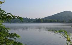 早晨，轻纱笼罩的湖水温柔，碧蓝，白雾在湖上方飘动