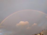 仰望彩虹，雨中打伞而过的美丽示例